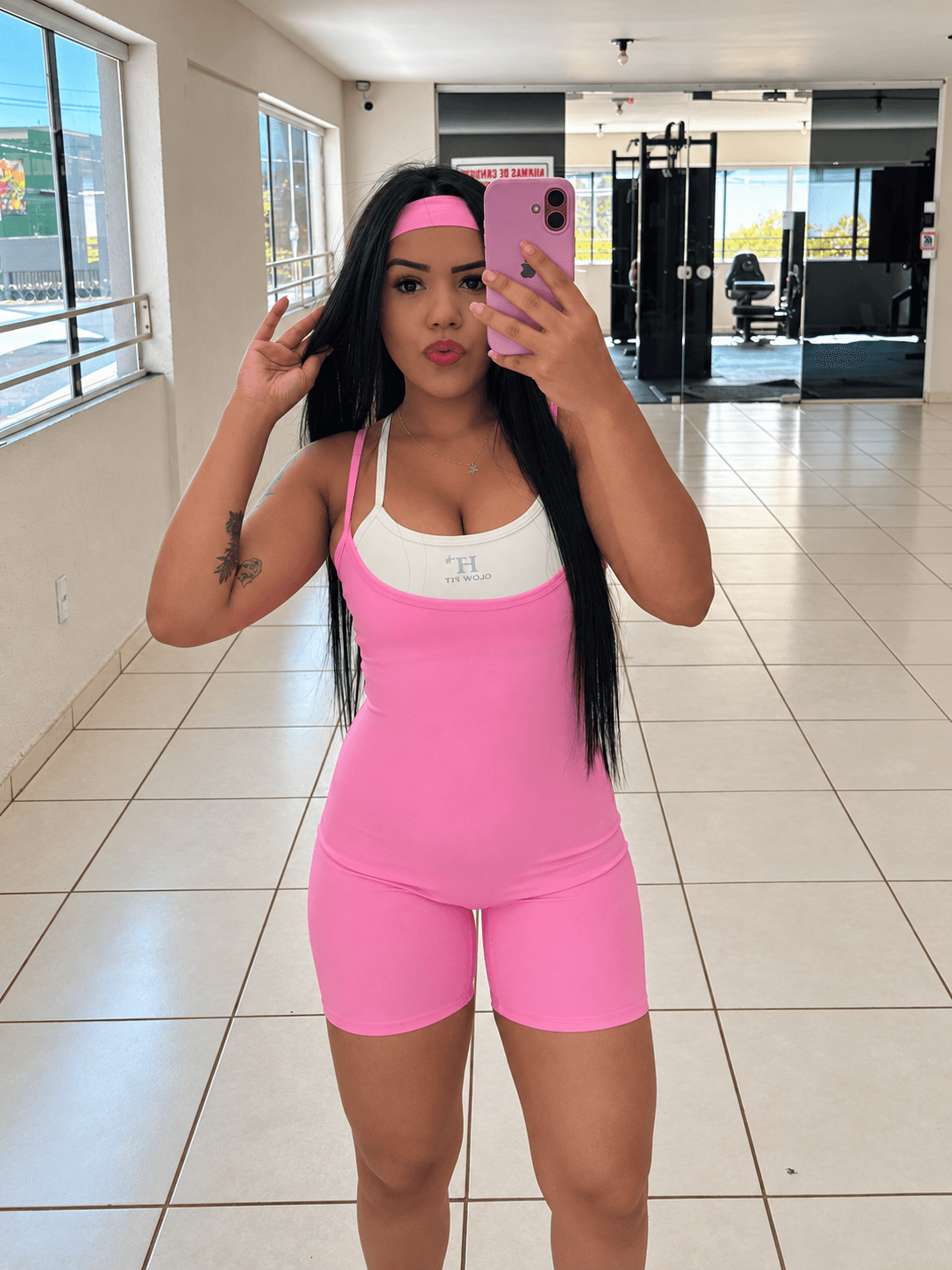 Modelo de Macaquinho Laura rosa fazendo foto no espelho da academia